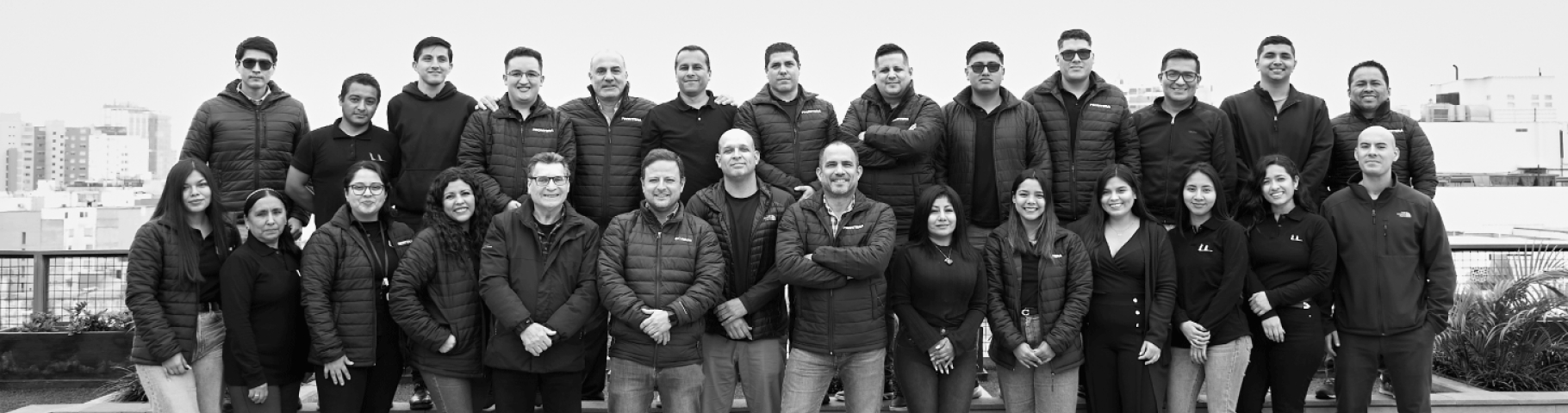 Equipo de Frontera Inmobiliaria, expertos en Departamentos en Venta en Lima, posando en una terraza urbana.